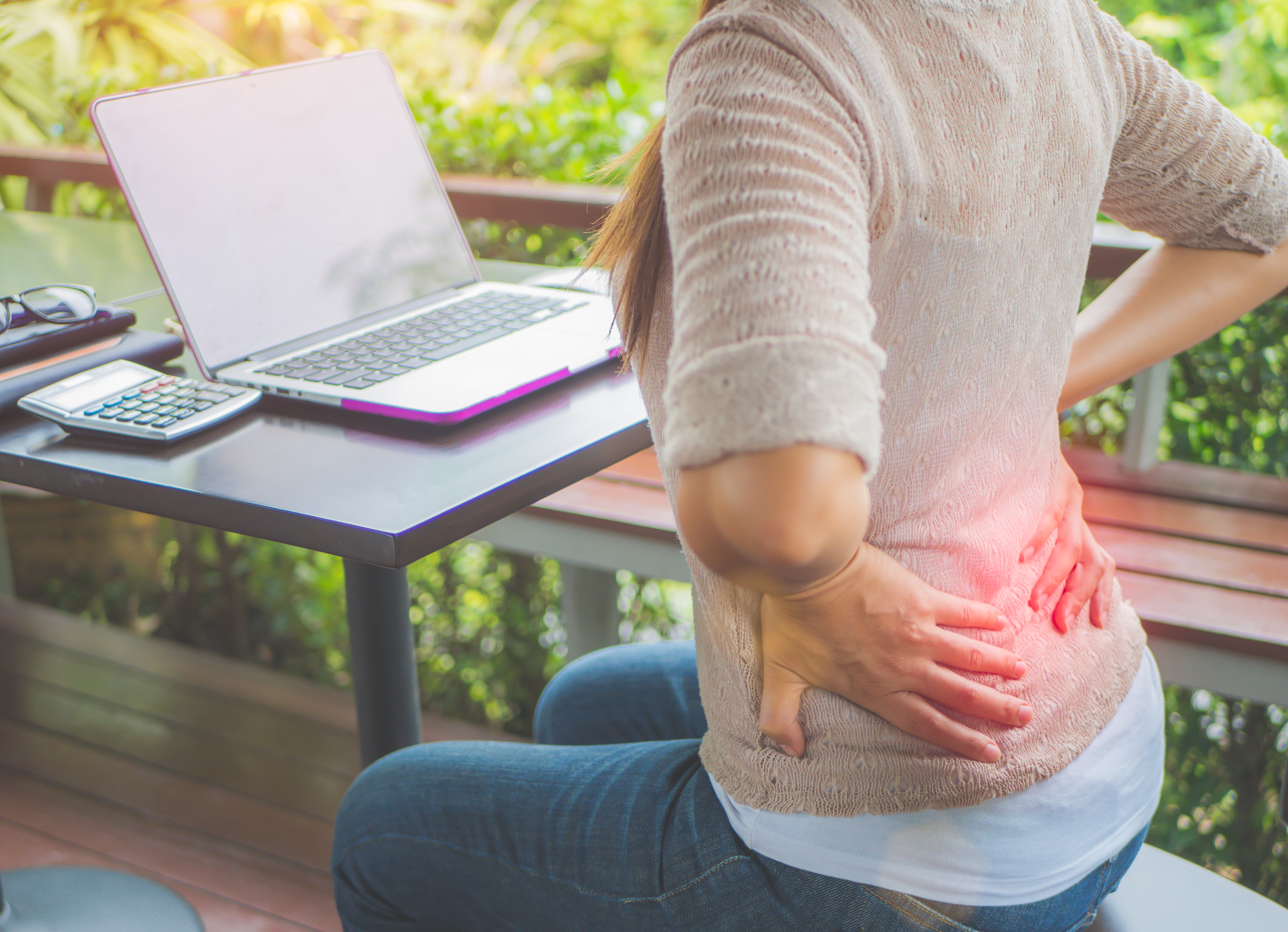 Frau im Freien mit Rückenschmerzen im Home-Office