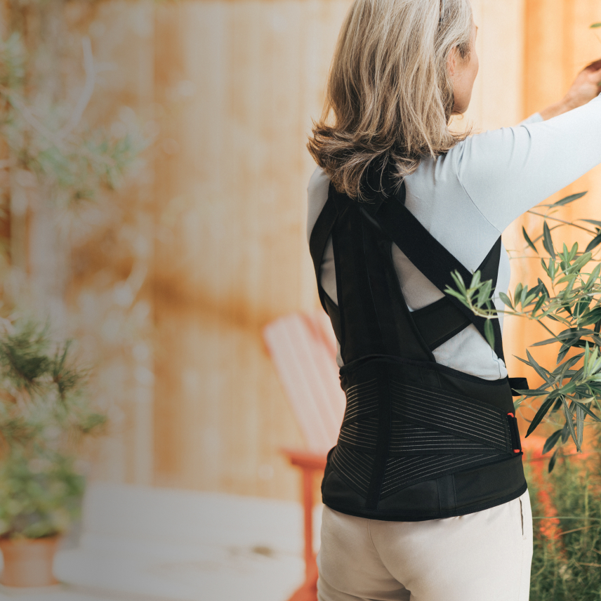 Imagebild DONJOY® OsteoStrap Frau im Garten, Rückenorthese zur aktiven Entlastung der LWS/BWS